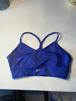 Reebok träningsbh - Klarblå träningsbh från Roben utan defekter. Inte säker på storlek men skulle säga en M