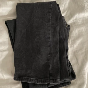 Bootcut - Säljer ett par svarta jeans med bootcut design och klassisk femficksdesign. Jeansen är i en lite längre modell. Bakfickorna är väldigt snygga med lock och knappstängning. Jeansen är i perfekt kondition, knappt använda.🌸