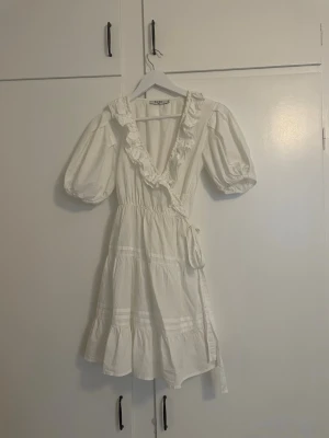 vit klänning - jättefin vit klänning från nakd med rosett i midjan o puffärmar, perfekt till student eller midsommar💗 endast använd en gång !