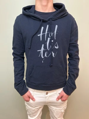  Hollister hoodie!! - En stilren mörkblå hoodie med ett skönt tryck. Märke:Hollister. Skick 9/10. OBS storlek S men passar XS.