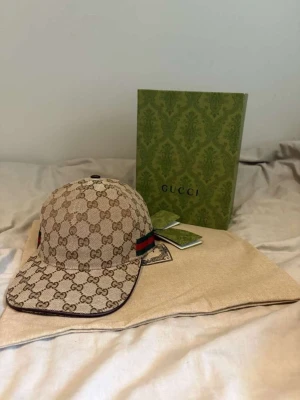 GG keps - Helt ny GG beige keps, storlek M, dustbag samt tags medföljer Box medföljer 