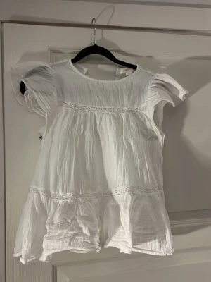 Vit sommarblus från Gina Tricot - Supersöt vit sommarblus från Gina Tricot. Vid en av armarna så har lite av tröjan gått upp vilket inte syns när man har på sig den. Som man kan se på bilden. 