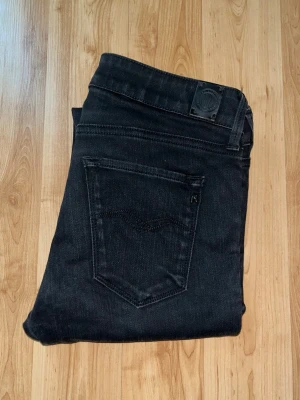 Replay jeans - Säljer ett par svarta Replay jeans i skinny fit. Midja 34cm, längd 102cm. JAG SKICKAR EJ FLER BILDER NÄR JAG BÄR JEANSEN! för bättre inblick i passformen rekommenderar jag att googla på modellnamnet. För storleksguide kolla måtten noggrant då jeansen alltid kan vara uppsydda heller krympta och jag ej tar emot returer :) 1,7