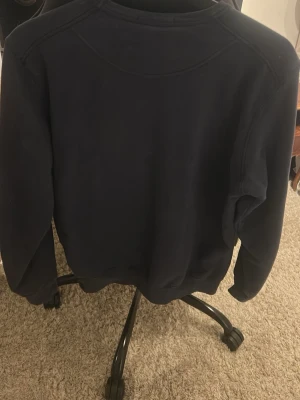 Mörkblå sweatshirt från Stone Island - Säljer en mörkblå sweatshirt från Stone Island. Riktigt schysst med den där sköna hrisch touchen, hör av er vid frågor