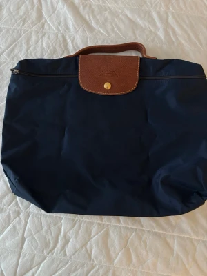 Long Champ - datorfodral - Long Champ datorfodral i bra skick! Säljer då det inte kommer till användning längre. Små defekter förekommer som: missfärgningar på undersidan och insidan, slitningar längst upp vid handtaget och längst nere i hörnen. (Finns bilder) 💕Inget som påverkar användningen dock! Mått: ca 38cm x 25cm. 💗