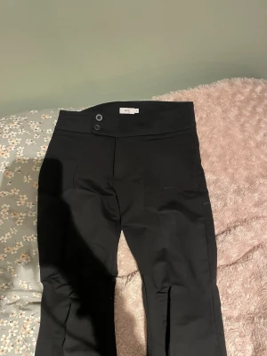 Svarta bootcut kostymbyxor från Nelly - Kostymbyxor från Nelly i skönt och mjukt tyg, dem är för korta för mig som har ungefär 81 cm i innerbenslängd. Men dem är i storlek S.