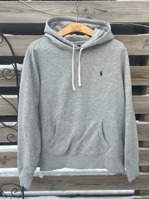 Ralph Lauren Grå Hoodie  - Riktigt snygg grå Ralph Lauren Hoodie. Storlek L men jag skulle säga att den passar bra på en M också. Bra skick, liten defekt på ena snöret men i övrigt fin. Hör gärna av er vid funderingar🙌Perfekt nu till vintern!☃️