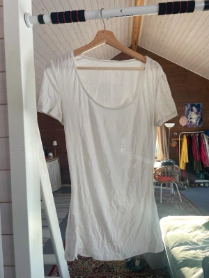 Vit basic t-shirt med rund hals - Enkel vit t-shirt med rundad halsringning och korta ärmar. Lätt/tunt och mjukt material. Ingen lapp men skulle säga storlek M, men mycket stretchigt material så passar även större.