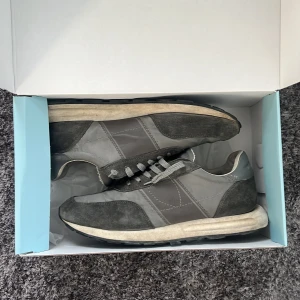 Grå Philippe Model sneakers i mocka och skinn - Säljer mina snygga och sällsynta sneakers från Philippe Model i olika grå nyanser. Ovandelen är i en mix av mocka och skin. perfekta för en avslappnad stil och en perfekt sko till vinter och vår. Skona har några defekter se bild för ex annars är dom i väldigt bra skick och mycket sparsamt använda. Nypris ca 2500