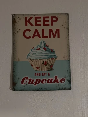 Plåt tavla - Jättecool plåt affisch som är köpt i London med texten "Keep calm and eat a cupcake"🧁⭐️gullig och perfekt inredning i rummet💕 köpt för 350kr och den är 30x40cm stor😄