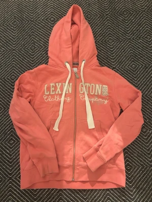 Lexington zip - En ljusrosa ziphoodie från Lexington.