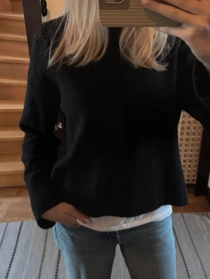 Stickad uniqlo tröja - Säljer en svart stickad tröja med breda, ribbade muddar och avslappnad passform. Tröjan har lång ärm och en enkel, stilren look som passar perfekt till jeans. Supermjuk och skön för kyligare dagar.