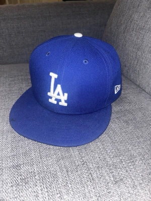 Blå new era keps LA - Blå LA New era officiella keps den som dem använder på matcher, säljer då den va för stor för mig nyskick bara använd några gånger är i storleken 7 5/8 60,6 cm 