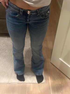 Ljusblå bootcut jeans med vanliga fickor 🫶 - Säljer ett par ljusblå jeans med bootcut passform och dubbla knappar i midjan. Är i storlek 164 och passar mig som är 34/36. Slutsålda från Gina Young 💕