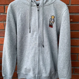 Raulph Lauren zip - Säljer en grå Raulph Lauren full zip som aldrig använts. Alla lappar sitter kvar. Säljer den då den inte passar mig. Det är storlek Large men den sitter som en Medium. R:ep 