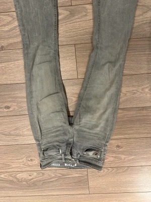 Grå bootcut jeans från Lois - Snygga grå jeans från Lois med bootcut-modell och klassisk femficksdesign. Jeansen har dragkedja, knapp och en liten detalj med logga på myntfickan. Tillverkade i jeansmaterial med en cool, lite tvättad look.