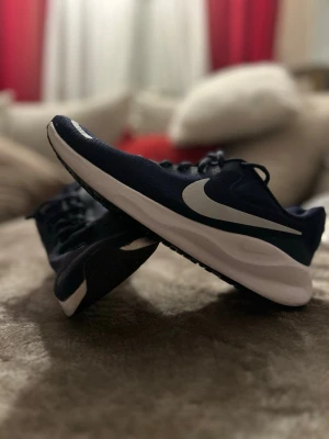 M Nike Revolution 7 marinblå sneakers - Hej! Jag säljer mina M Nike Revolution 7 löparskor. De har endast använts inomhus vid träningstillfällen och har omhändertagits väl hand om. Nytt pris 750kr, mitt pris 500kr. Kontakta mig gärna vid intresse priset kan diskuteras vid snabba köp.