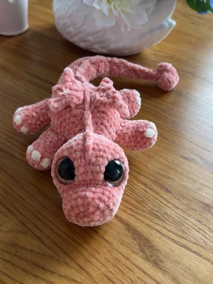 Liiiten orange drake🧡🐉 - Här har jag virkat en liiiten orange drake med oranga ögon🧡🐉 Den är mindre än de andra drakarna🐉 Den är gjord på mjukt garn och har hårda gröna ögon som inte går att ta av🧡 Den är stoppad med mjukstoppning🐉🥰 älskar att virka och hoppas denna gör någon glad🥰Den är 35 cm om man sträcker ut svansen🧡🧡🧡