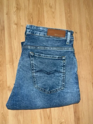 Replay jeans - Säljer ett par blå jeans från Replay i straight fit. Jeansen har fake hål på benen. Midja 41cm, längd 104cm. OBS Jeansen haft defekt med är väl sytt efter. JAG SKICKAR EJ FLER BILDER NÄR JAG BÄR JEANSEN! för bättre inblick i passformen rekommenderar jag att googla på modellnamnet. För storleksguide kolla måtten noggrant då jeansen alltid kan vara uppsydda heller krympta och jag ej tar emot returer :) s6,1