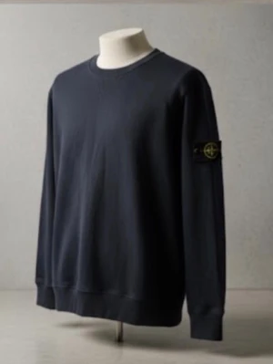 Mörkblå sweatshirt från Stone Island - Säljer en mörkblå sweatshirt från Stone Island med klassisk rund hals och ikonisk patch på vänster ärm. Tröjan är i mjuk bomull och har ribbade muddar vid ärmslut och nederkant. Perfekt för dig som gillar stilrena och tidlösa plagg.    pris kan diskuteras!😉