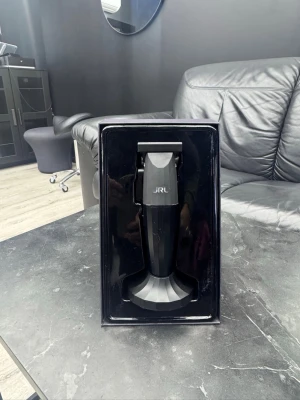 JRL svart hårtrimmer - Snygg svart hårtrimmer från JRL med ergonomiskt grepp och skarpa metallblad. Perfekt för att fixa detaljerade frisyrer och linjer. Kommer i en stilren förpackning med laddningsställ. Passar både hemma och i salong. Metallbladen är helt nya.