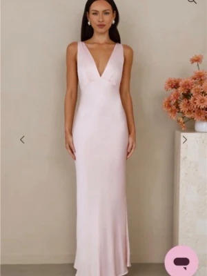 Ljusrosa balklänning  - Supersnygg ljusrosa långklänning med djup v-ringning och smala axelband. Klänningen har en bra passform och faller snyggt längs kroppen. Perfekt för balen. Jag säljer denna på grund av att jag inte kunde ha den. Därför dessa bilder. Prislapp kvar. Endast testad en gång. Från hellomolly.