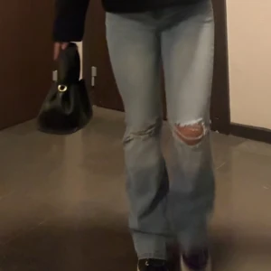 Populära jeans från Nelly - Så snygga jeans från Nelly med hål på knäna och knappar på bakfickorna 💞lite slitna längst ner 