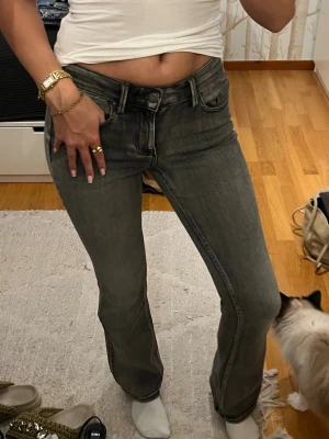 Grå bootcut jeans från Vero Moda - Säljer ett par gråa jeans från Vero Moda med bootcut passform och låg midja. Bootcut jeans och är tillverkade i mjukt denimtyg. Superbrkväma och stretchiga! Aldrig använda 