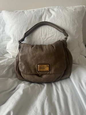 Väska Marc by Marc Jacobs - Säljer min snygga och populära Marc Jacobs väska. Fin beige färg som passar till allt! Kommer tyvärr inte till användning längre 