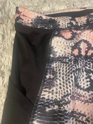 SOC leggings med mönster, strl 158/164 - Snygga leggings från SOC med rosa mönster som påminner om ormskinn. Materialet är stretchigt och passar perfekt för träning. Logga på benet och superskön passform!💕💕