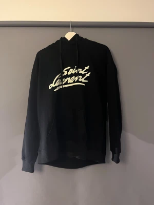 Saint Laurent hoodie - Svart hoodie från Saint Laurent. Perfekt för en clean look. Är lite liten i storleken men passar både L och M