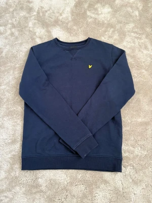 Mörk blå Lyle & scott tröja - En mörk blå tröja från lyle & scott för 14/15 år knappt använd och i väldigt bra skick! Passar fint till alla årstider och väldig mjuk och skön