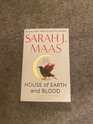 House of Earth and Blood - Upptäck en spännande bok av Sarah J. Maas! House of Earth and Blood är första delen i Crescent City-serien. Omslaget har en mystisk fågel och en gyllene måne – perfekt för dig som gillar fantasy och episka äventyr. HELT NY