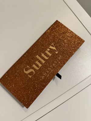 Sultry ögonskuggspalett från Anastasia Bevery Hills  - Sultry ögonskuggspalett från Anastasia Beverly Hills med 14 nyanser i både matta & skimrande färger. Aldrig använd endast den svarta färgen testad. Köpt från kicks runt 560kr. 