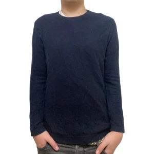 Riley tröja  - Snygg mörkblå stickad tröja från Riley med rund hals och ribbade muddar vid ärmslut och nederkant. Tröjan har en klassisk, enkel design och är långärmad, perfekt för dig som gillar stilrena plagg med skön passform.