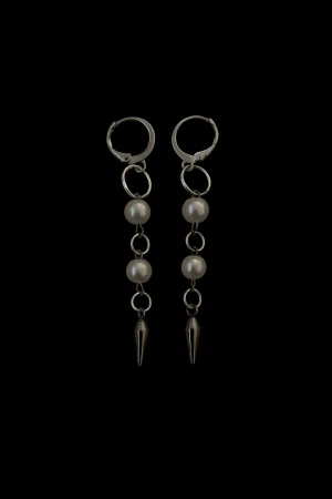 Silvriga örhängen med pärlor och spikes - Säljer ett par coola silvriga örhängen med två vita pärlor och en metallspets längst ner. Hängande design med ringar mellan varje detalj. Perfekt för dig som gillar edgy och stilrena accessoarer.