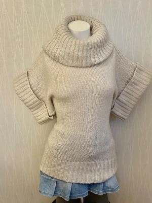 kortärmad polotröja - en cremefärgad, kortärmad polotröja med ribbad krage och ribbade muddar Det står S men det är oversized