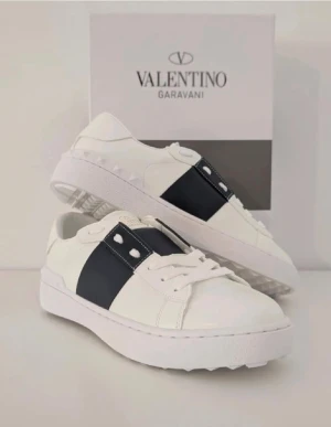 Valentino Opens sneakers vit/svart - Snygga Valentino Garavani Open sneakers i vitt skinn. Färg: Svart. Ingår Box. Köpt för 2000 kr endast använda 2 gånger. Priset går att diskuteras. Ingår box och påse