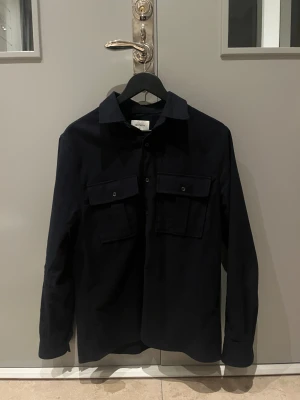 Mörkblå overshirt från Brothers M - Mörkblå overshirt i storlek M. Nypris = 1200kr Mitt pris = 599kr. Nästan aldrig använt den, Inga defekter men saknar prislapp, Hör av er vid snabb affär. Bvsa 