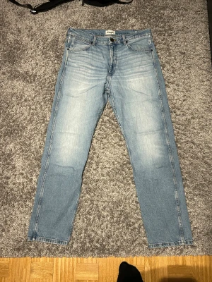 Wrangler jeans - Schysta Wrangler jeans i bra skick. Passformen är relaxed. Den har en liten vit fläck, vet inte var det kan ha kommit ifrån men det kan vara ett fel i produktionen. 