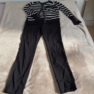 Svartvit randig kofta från Primark och svarta  byxor - Mjuk kofta från Primark med ränder & knappar + snygga, bekväma byxor. Perfekt kombo för en stilren vardagslook!  💸 Kofta 49 kr | Byxor 39 kr | Paketpris 75 kr 🙌🌸 🤝 Brukar acceptera prisförslag & säljer mycket billigt – kika gärna på mina andra annonser! 