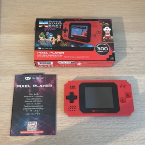 Pixel Player Portable Gaming System - Kan mötas i Stockholm vart som! Köpt i Danmark och har ett original värde på 700kr, spelat klart alla 300+ spel och används inte mer. Pris går att diskutera: beskrivning - My Arcade Pixel Player är en portabel retro-spelkonsol med 300 inbyggda 8-bitars spel, inklusive klassiker som Bad Dudes och Caveman Ninja. Konsolen är i rött utförande, levereras med originalkartong och manual, och är i mycket gott skick utan synligt slitage. Perfekt för retrospel-entusiaster!
