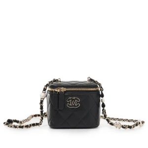 Chanel svart quiltad axelväska - Supersnygg svart quiltad axelväska från Chanel med ikoniska CC-detaljer i silver och pärl-liknande dekorationer på kedjeremmen. Väskan har rund form, dragkedja upptill och är tillverkad i skinn. Perfekt för dig som vill ha en statementväska med lyxig känsla.