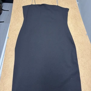 Svart kort klänning  - En svart kort klänning med glitterband i storlek M