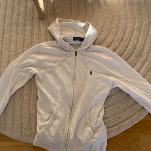 Vit hoodie från Polo Ralph Lauren XS - Säljer en vid Ralph lauren zip hoodie i stl xs men passar även som S använd i mycket bra skick, säljer den eftersom jag inte använder den längre.
