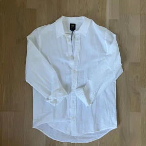Vit linneskjorta från Lee, M - Klassisk vit skjorta från Lee i luftig linneblandning. Skjortan har lång ärm, knappar framtill och en avslappnad passform. Perfekt för en clean och fräsch look. Diskret Lee-brodyr på bröstet och regular fit. Lapp kvar för att jag aldrig använt den.