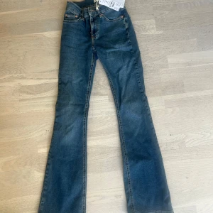 Blå bootcut jeans Perfect Jeans från Gina Tricot! - Snygga blå bootcut jeans från Perfect Jeans med låg midja. Klassisk femficksmodell med kopparfärgade nitar och läderpatch bak. Jeansen är i stretchig bomullsdenim och har en schysst tvättad look.