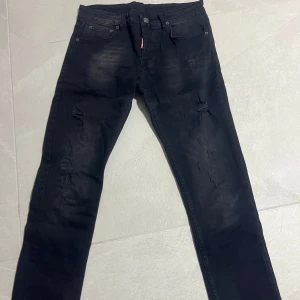 Dsquared2 jeans - Snygga svarta jeans från Dsquared2 med tydliga slitningar och distressed detaljer framtill och baktill. Är i nyskick! Strl 156-164