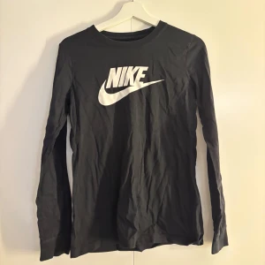Svart långärmad Nike tröja - Svart långärmad tröja från Nike med stor vit logga framtill. 