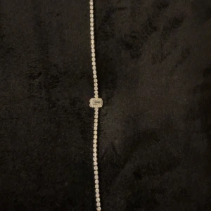 Glittrigt silverarmband med stenar - Snyggt och glittrigt armband i silverfärg med små gnistrande stenar längs hela bandet. Armbandet har en rektangulär detalj i mitten som är täckt av ännu fler stenar för extra bling. Perfekt accessoar för att lyfta din outfit.